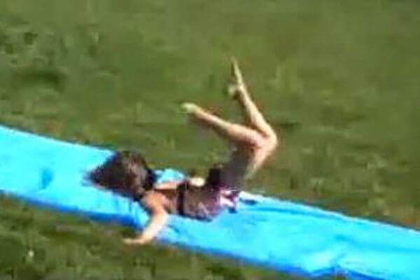Child face-planting on a slip-n-slide