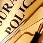 Extreme close-up of title of insurance policy with quill pen on top.