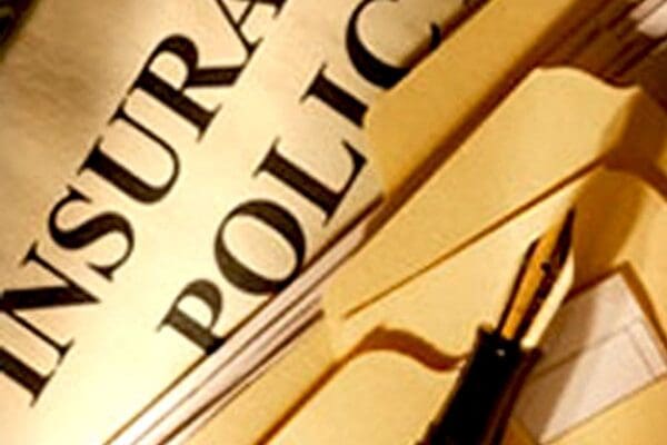 Extreme close-up of title of insurance policy with quill pen on top.